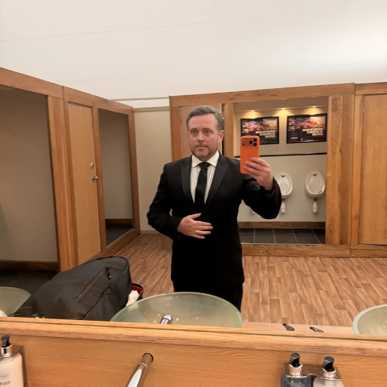 Laurence Bray taking a mirror selfie after changing into his suit
